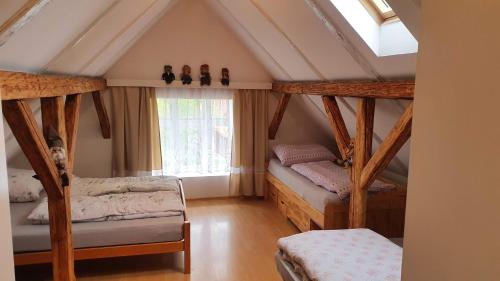 a attic room with two bunk beds and a window at Chata u potoka in Lázně Bělohrad