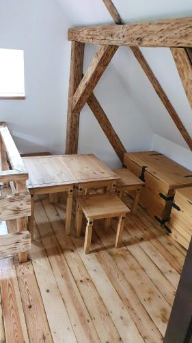 a wooden table and benches in a room with wooden floors at Chata u potoka in Lázně Bělohrad