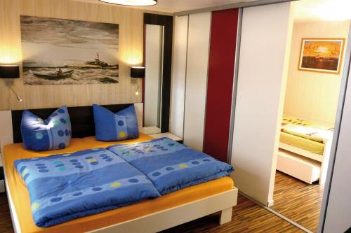 a bedroom with a bed with blue pillows in it at Achterdeck FW 2 in Zingst