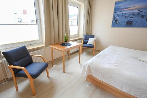 a bedroom with a bed and two chairs and a table at Zur schönen Aussicht - FW 5 in Dahme