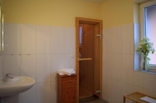 een badkamer met een wastafel, een toilet en een deur bij Fehmarnstrand 78 RH 7 in Staberdorf