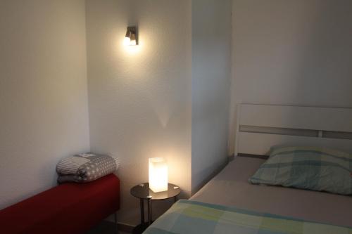 a small bedroom with a bed and a light on the wall at Hasen Apartment Lingen in Lingen