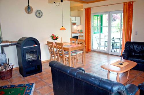 uma sala de estar com um sofá e um fogão a lenha em Ferienhof Rauert Haus 1 em Todendorf auf Fehmarn