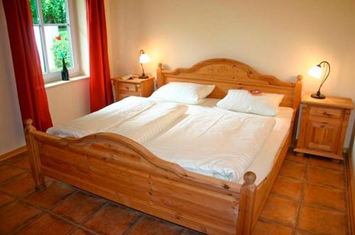 uma grande cama de madeira num quarto com uma janela em Ferienhof Rauert Haus 1 em Todendorf auf Fehmarn