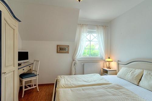 a bedroom with a bed and a desk and a window at Villa Carpe Diem, FW 8 in Zingst