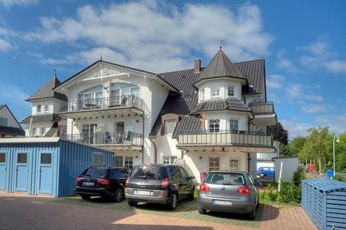 a large house with cars parked in front of it at Villa Carpe Diem, FW 8 in Zingst