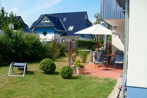 a backyard with a table and chairs and an umbrella at Villa "Meereslust", Whg 2 in Zingst