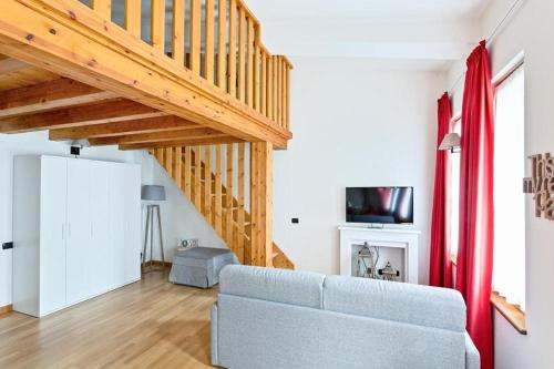 a living room with a couch and wooden stairs at Gressoney Saint-Jean apartments by Halldis in Gressoney-Saint-Jean