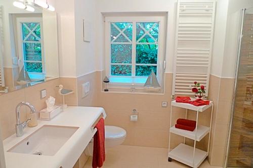 a bathroom with a sink and a toilet and a window at Kapitän ParowBrigantine in Zingst