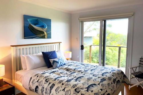 a bedroom with a bed and a large window at Apollo Ocean Blue ~ Oceanview ~Wifi ~Pet Friendly in Apollo Bay