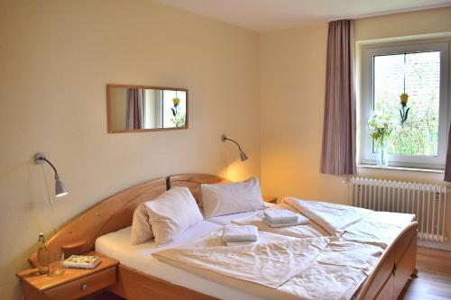 a bedroom with a large bed with white sheets and a window at Am Hinrichsberg unten in Staberdorf