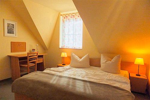 ツィングストにあるAm Deich 35のベッドルーム1室(ベッド1台、デスク、窓付)