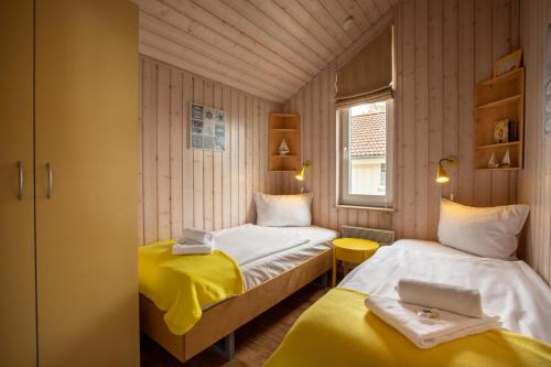 ペルツァーハケンにあるTyp C "Santa Maria" -Fjordhaus-のベッド2台とノートパソコンが備わる小さな客室です。