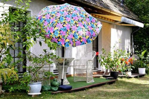 eine Terrasse mit einem Sonnenschirm und einem Stuhl und einigen Pflanzen in der Unterkunft Eden 1 Zimmer Appartment in Hoppegarten
