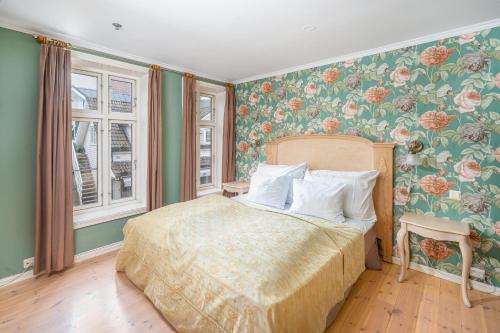 a bedroom with a bed with floral wallpaper at GamlaVærket Gjæstgiveri og Tracteringssted in Sandnes