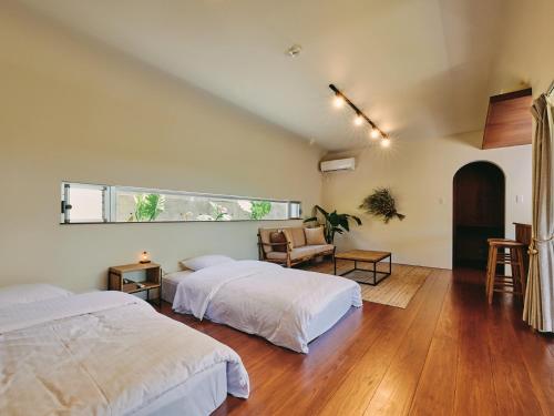 a bedroom with two beds and a window at IMAGINE OKINAWA -stay- in Nakijin