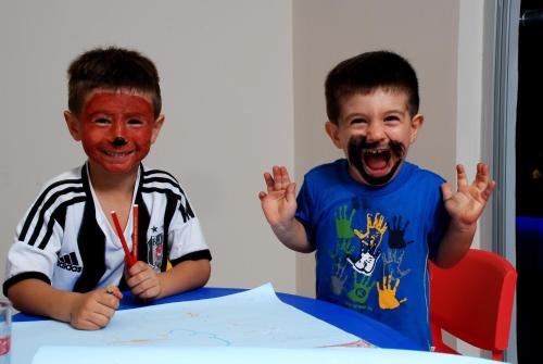 two young boys with painted faces sitting at a table at Kleopatra Ramira Hotel - All Inclusive in Alanya