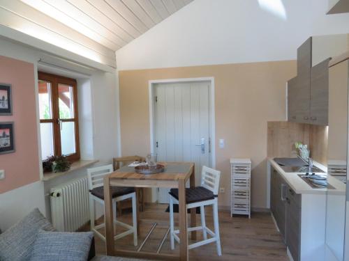 a kitchen with a table and chairs in a room at Ferienwohnung Vöst in Peiting