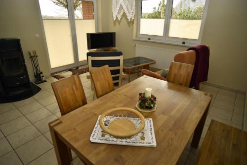 een eetkamer met een houten tafel en stoelen bij Ferienhaus am Vogelpark - Trebelhaus Gesine in Marlow