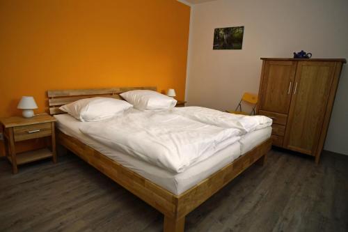 een slaapkamer met een bed met witte lakens en kussens bij Ferienhaus am Vogelpark - Trebelhaus Gesine in Marlow