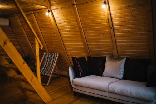a couch and a chair in a room with wooden walls at Cottage Sataplia in Kutaisi
