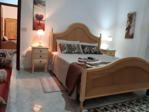 a bedroom with a large bed with a wooden headboard at Locanda 130 in Fonni