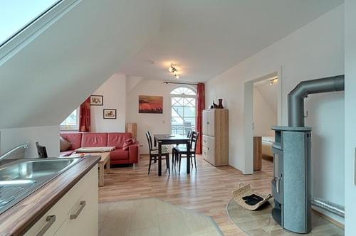 uma cozinha e sala de estar com fogão a lenha em Villa Carpe Diem, FW 9 em Zingst