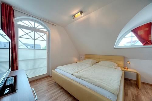 um quarto com uma cama e uma grande janela em Villa Carpe Diem, FW 9 em Zingst