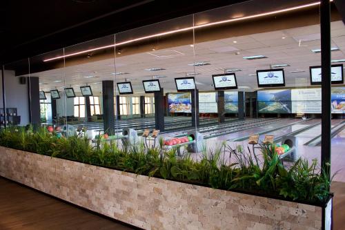 an airport baggage claim area with plants and televisions at Grand Hotel Velingrad in Velingrad