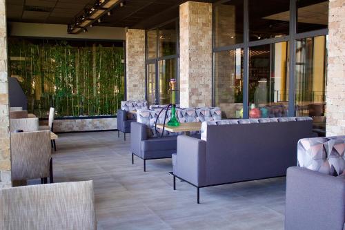 a restaurant with couches and a table and chairs at Grand Hotel Velingrad in Velingrad