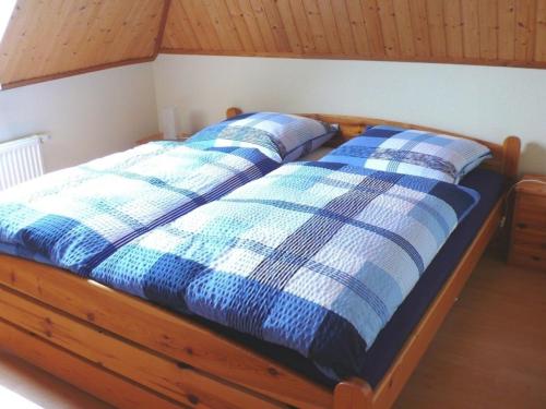 uma cama com duas almofadas azuis e brancas em Ferienwohnung Uferschwalbe em Rerik