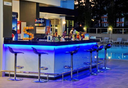 a bar with stools in front of a pool at Kleopatra Ramira Hotel - All Inclusive in Alanya