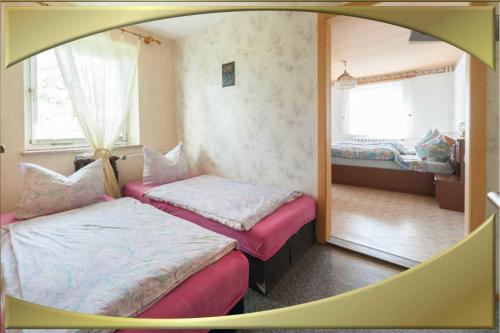 a room with two beds and a mirror at Ferienwohnung - 59100 in Kurort Altenberg
