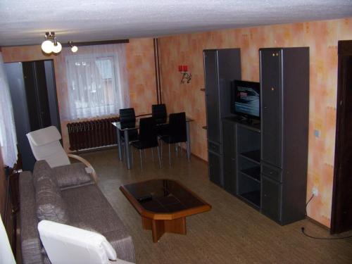 ein Wohnzimmer mit einem Sofa und einem Tisch in der Unterkunft Ferienwohnung - 59100 in Kurort Altenberg