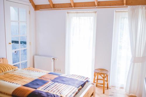 a bedroom with a bed and two large windows at Haus Irsa in Sellingen