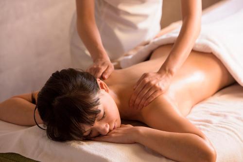 a woman getting a back massage from a therapist at Hotel Metropolitan Premier Taipei in Taipei