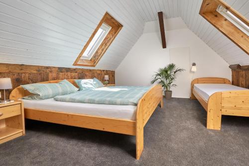 a bedroom with two beds in a attic at Ferienhof Wuchner - Fewo "Sommerwiese" in Fröhnd