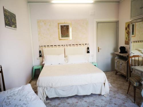 ein Schlafzimmer mit einem großen weißen Bett und einer Kommode in der Unterkunft B&B L ORTENSIA in Bolsena
