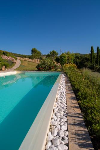 a swimming pool with rocks around it at Cavarchino B&B in Gaiole in Chianti