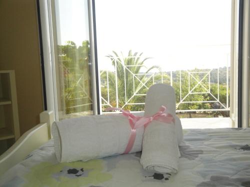 a bed with rolled towels on it with a window at Fiora Villas in Trapezaki
