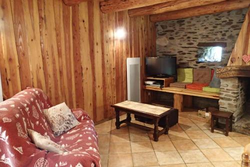 un salon avec un canapé et une télévision dans l'établissement artiguelongue grange restaurée, à Loudenvielle