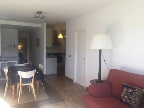 uma sala de estar com uma mesa e um sofá vermelho em Apartamento Balcón de Jaca em Jaca