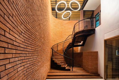a spiral staircase in a building with a brick wall at Cross Chiang Mai Riverside in Chiang Mai