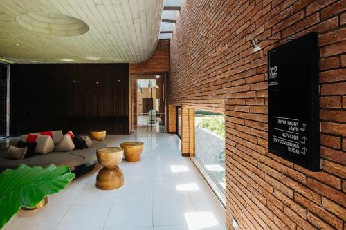 a living room with a couch and a brick wall at Cross Chiang Mai Riverside in Chiang Mai