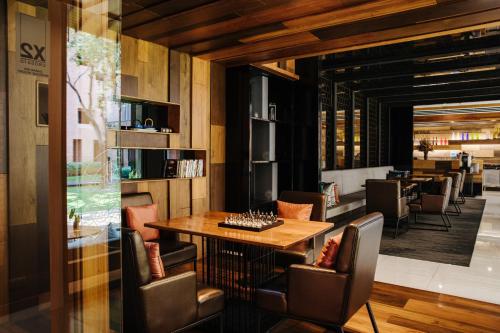 a dining room with a wooden table and chairs at Cross Chiang Mai Riverside in Chiang Mai