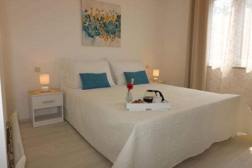 una camera da letto con un letto bianco con cuscini blu di Residence Lorena Bungalow Lavanda 1 a Poreč (Parenzo)