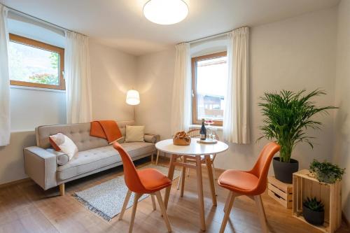 un soggiorno con divano, tavolo e sedie di Dorfapartment Achensee a Maurach