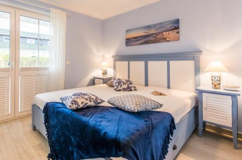 een slaapkamer met een bed met blauwe lakens en kussens bij Whg 02 - MeerFreude in Zingst