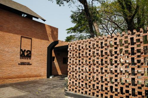 a brick wall in front of a building at Cross Chiang Mai Riverside in Chiang Mai