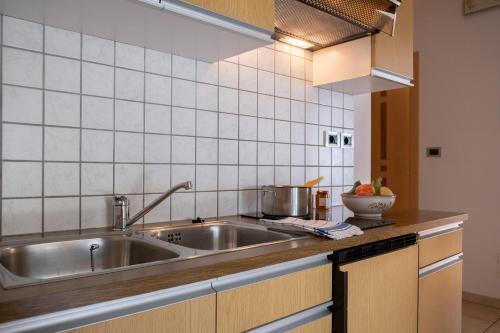 eine Küche mit einer Spüle aus Edelstahl und einer Theke in der Unterkunft Ferienwohung im Haus Texel I in Rabland